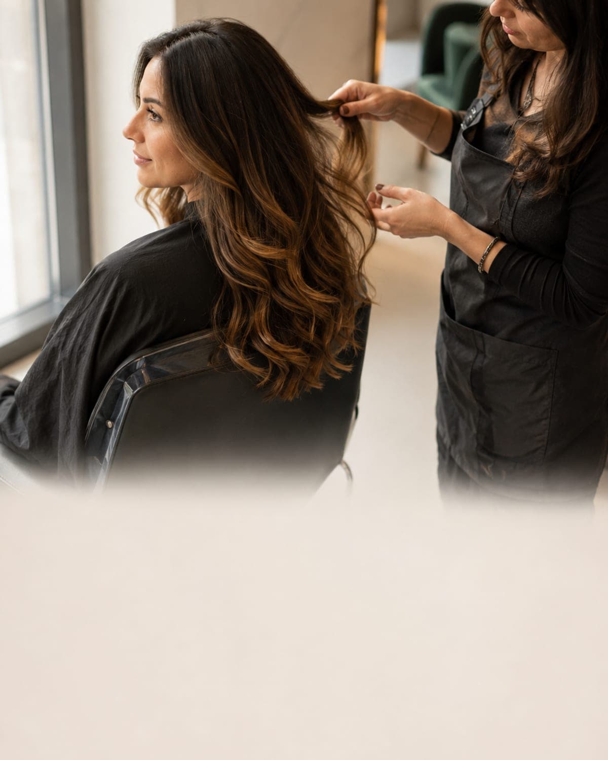 Clientă cu balayage natural, coloristă verificând nuanța la lumina ferestrei, salon MegaSun